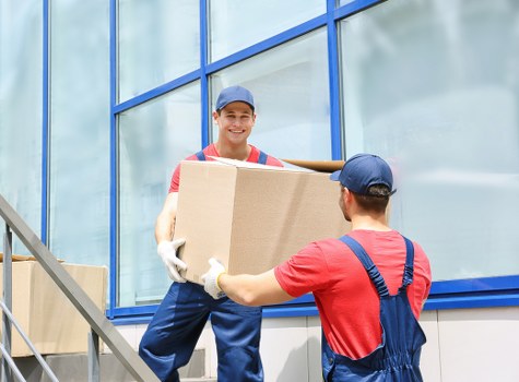 Household furniture being carried through a Hackney property