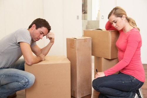 Removal workers handling furniture in a Hackney property with stairs