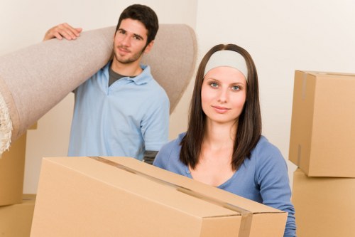 Professional movers carrying household items down stairs in Hackney